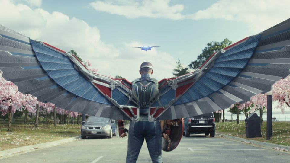 Captain America stands in a field with mechanic wings spread wide.