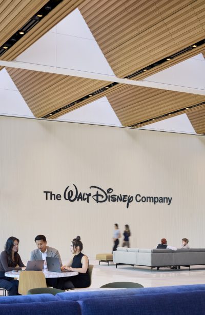 Employees in the Great Room with The Walt Disney Company logo displayed on the wall by Dave Burk – SOM © 2024 Disney